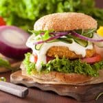 A veggie burger with a crispy patty, sauce and vegetables