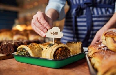 Sales Assistant In Bakery Putting Vegan Label Into Freshly Baked Baked Savoury Roll